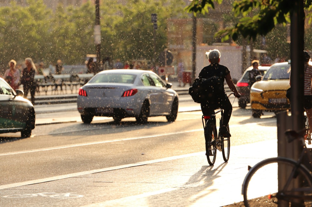 A cyclist riding through rain at golden hour