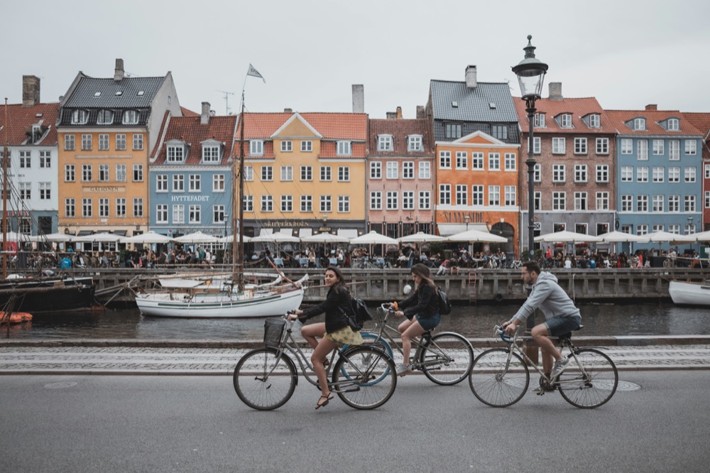 Cyclists passing the colourful houses of Nyhavn